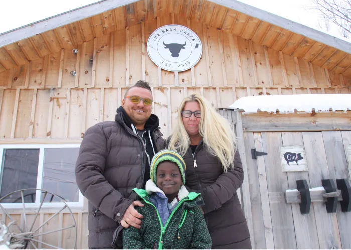 The owners of The Barn Chefs posing for the camera in front of their business.