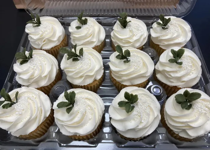 Twelve decorative cupcakes in a tray on display